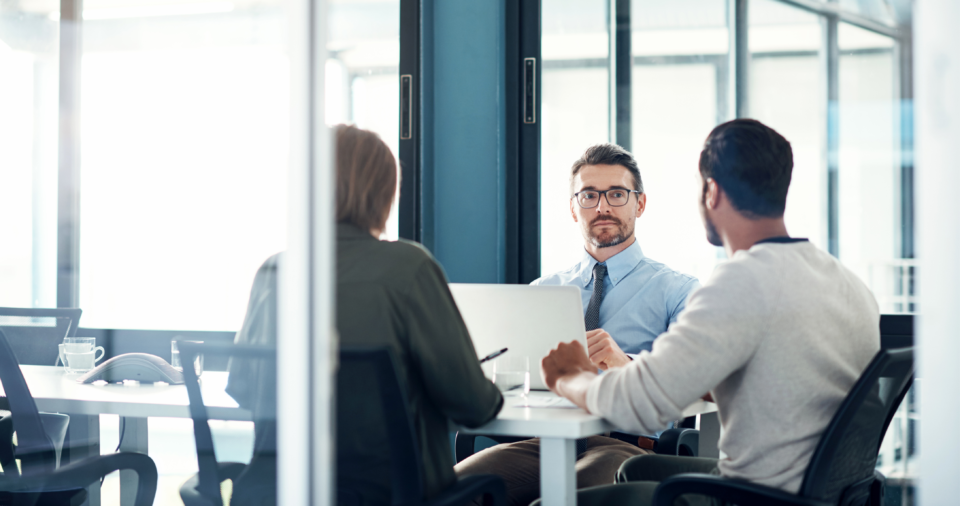 A man sitting and listening to his team during an advanced sales training session
