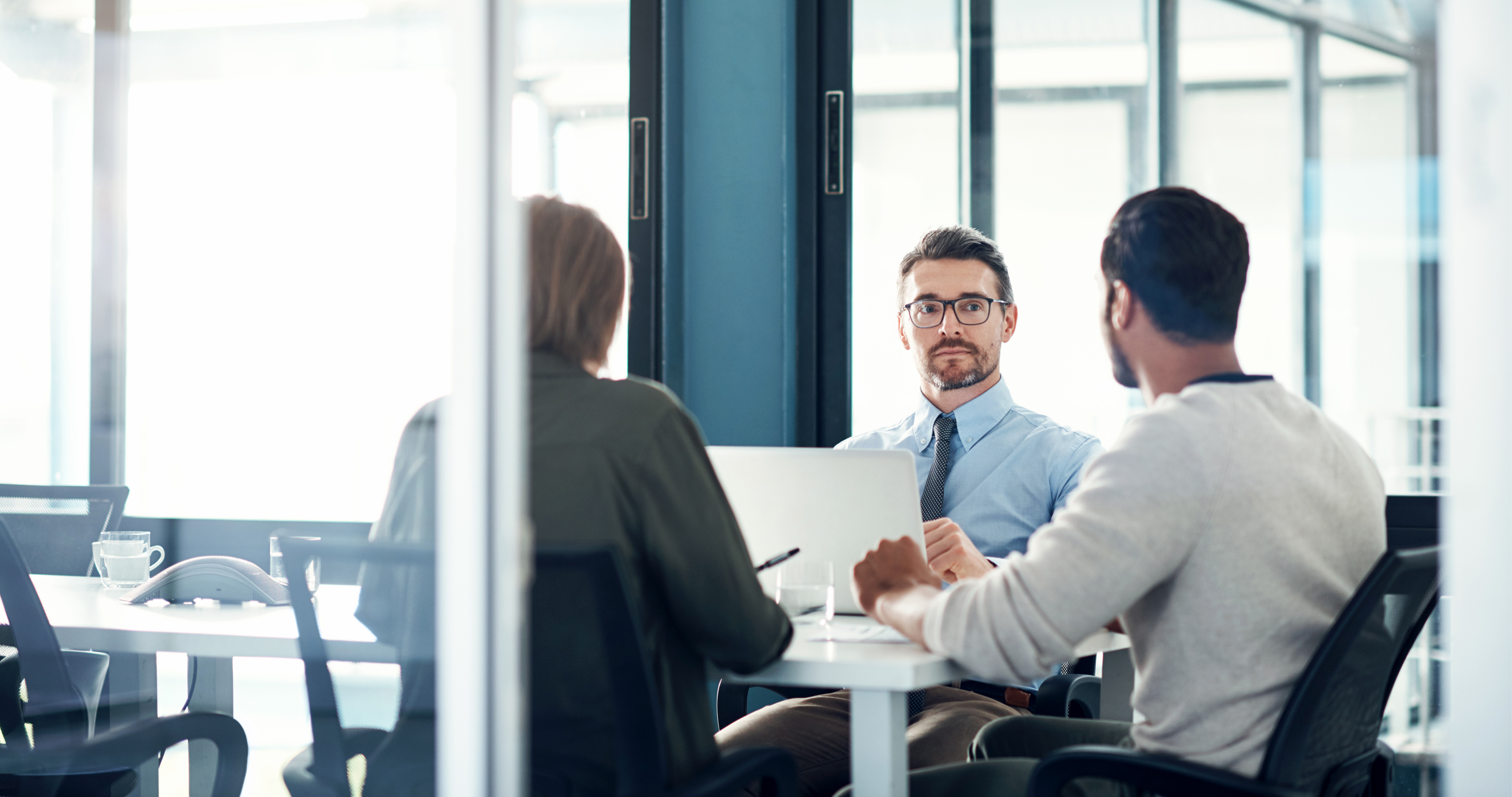 A man sitting and listening to his team during an advanced sales training session