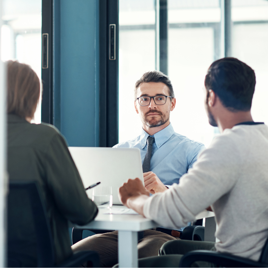 A man sitting and listening to his team during an advanced sales training session